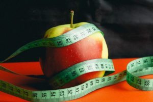 image of red and yellow apple on an orange table with green measuring tape around it for Pennsylvania Health Care Insurance