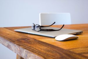 image of glasses on top of a computer and wood table for Pennsylvania Third Party Administrator